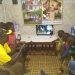 A Kenyan family enjoying the benefits of the Sun King Home 400 with a 24-inch TV