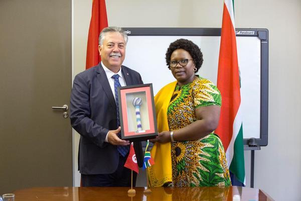 Deputy minister of trade and industry Nomalungelo Gina hands a " Proudly South African" gift to Tunisian secretary of state for foreign affairs Sabri Bachtoji - The Exchange