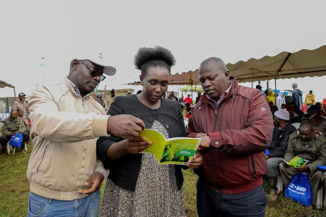 Evelyn Koiyan, CEC Agriculture Narok County with (right) Lawrence Maina, General Manager, East Africa Maltings ltd (EAML), and Prof Julius Ochuodho go through the 8th edition of the Barley Growing Handbook. www.theexchange.africa