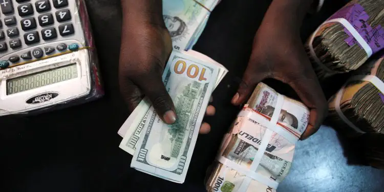 A trader changes dollars for naira at a currency exchange store in Lagos, Nigeria, February 12, 2015.   REUTERS/Joe Penney: Exchange