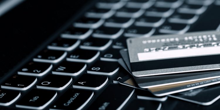 Credit cards and a laptop. Financial crime will continue growing in Sub-Saharan Africa but digital money platforms should offer forward-thinking compliance functions. www.theexchange.africa