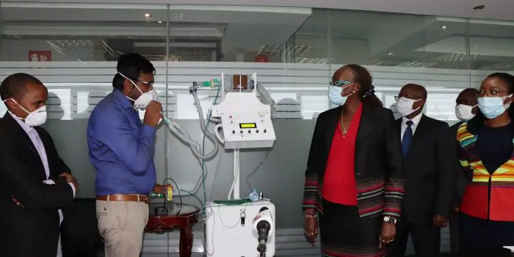 Ashit Shah, KAM Automotive Sector Chair & Mutsimotor Director explains how a Kenyan manufactured ventilator works to Industry CS Ms Betty Maina (R). The PUMUAISHI 2.0, ventilators will be used by local hospitals to fight the covid-19 pandemic. www.theexchange.africa