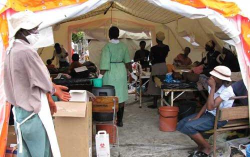 People receiving medical care in tent