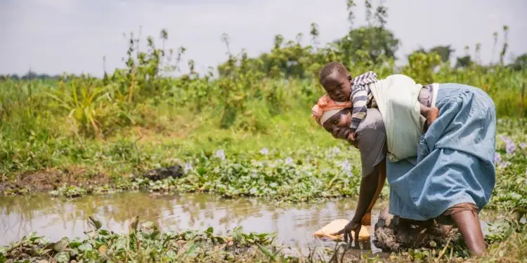 A woman and her child fetching water from a swamp in Kikomera Biri village in Uganda. Communities have to also play a role in ensuring that their water rights are addressed. www.theexchange.africa