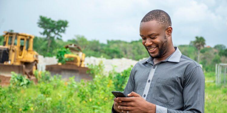 A man using a mobile phone. EWS by 4G Capital enables an early assessment of borrowers to help reduce the risk of over-indebtedness. www.theexchange.africa