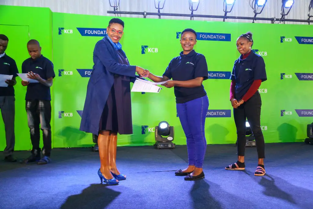KCB Group Director Marketing, Corporate Affairs & Citizenship, Rosalind Gichuru offers a scholarship certificate to one of the 251 beneficiaries who will be taken through the University through the KCB Foundation Education Scholarship Program. https://theexchange.africa/