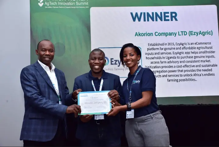 (L-R) Dr. Henry Nakalet Opolot, Project Coordinator for ACDP and Assistant Commisioner at Ministry of Agriculture, Industry and Fisheries, Government of Uganda hands over the winning certificate and award to William Luyinda, CEO & Co-Founder of EzyAgric and Esther Karwera Co-Founder & Chief Commercial Officer, EzyAgric Uganda.